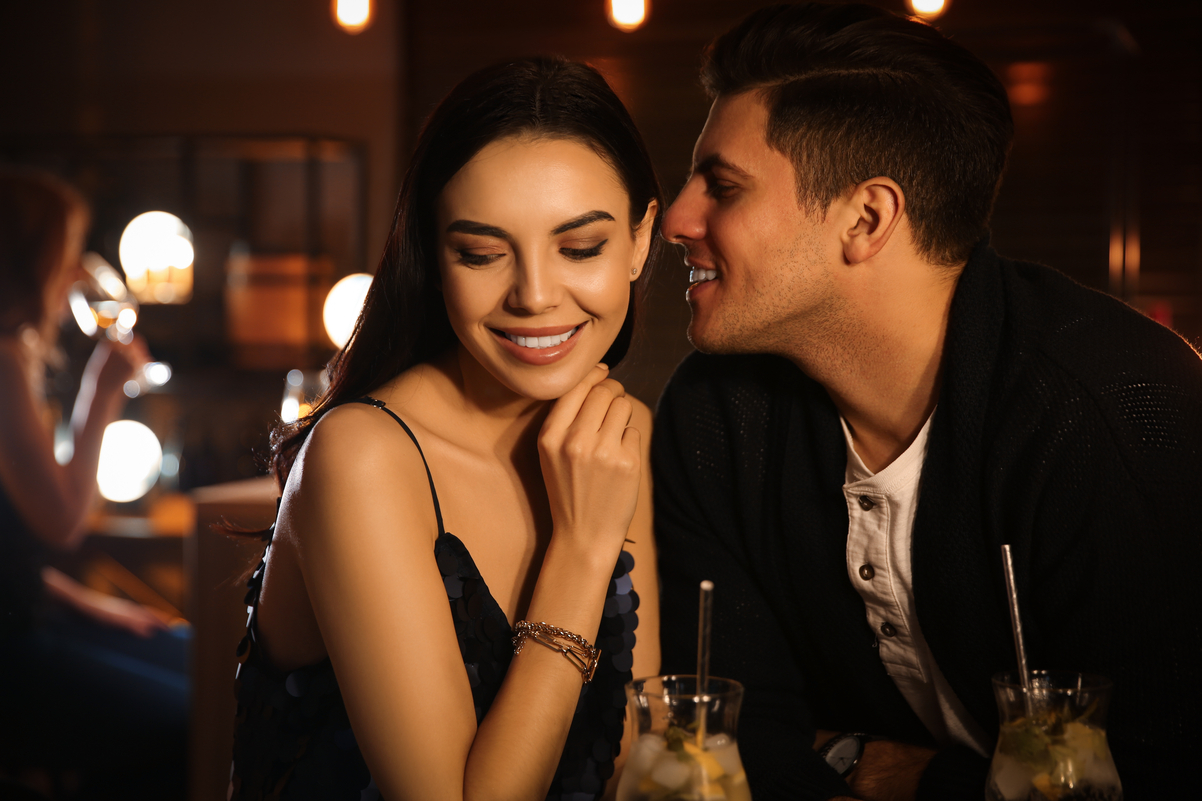 Duas pessoas flertando em um bar: será que algum deles é dos signos mais atraentes?